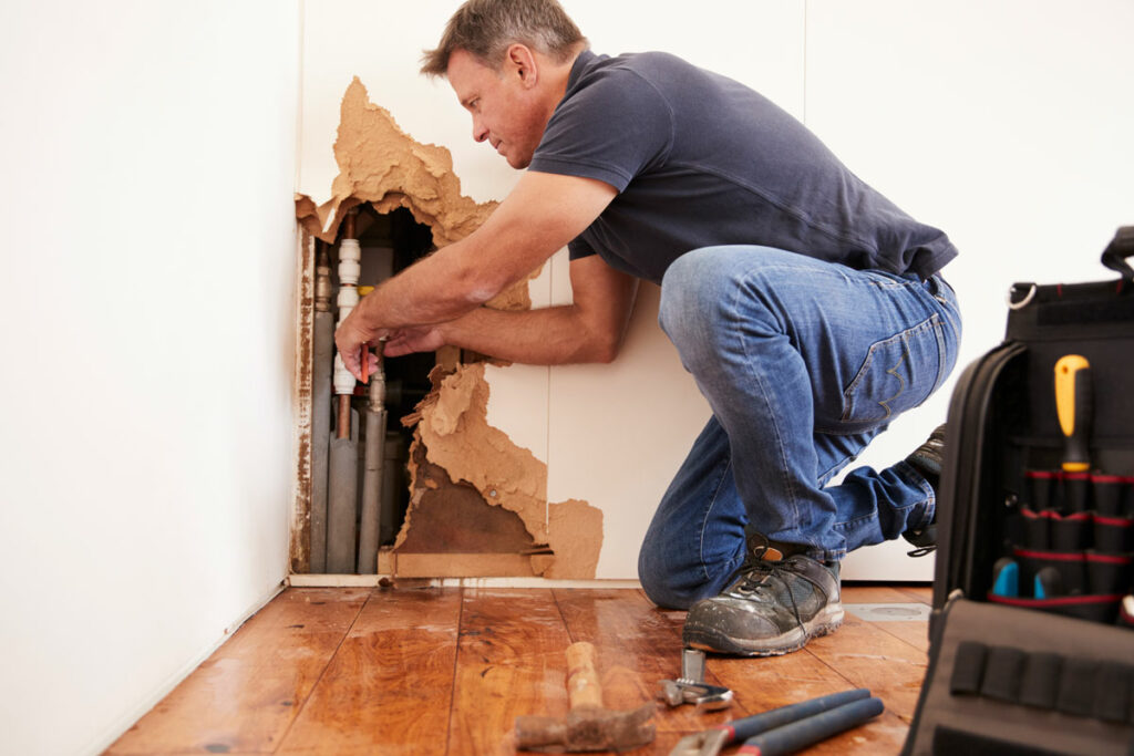 Man Repairing a Broken Pipe for Water Damage Clean Up in Morton Grove, Chicago, Des Plaines, Northfield